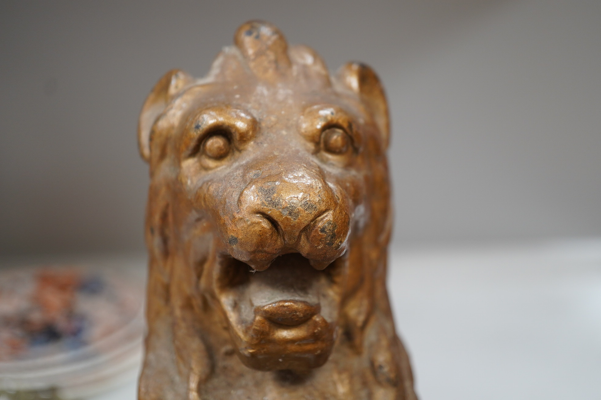 A pair of cast iron fire dogs in the form of triumphant lions, painted, 38cm high, 23cm wide. Condition - fair